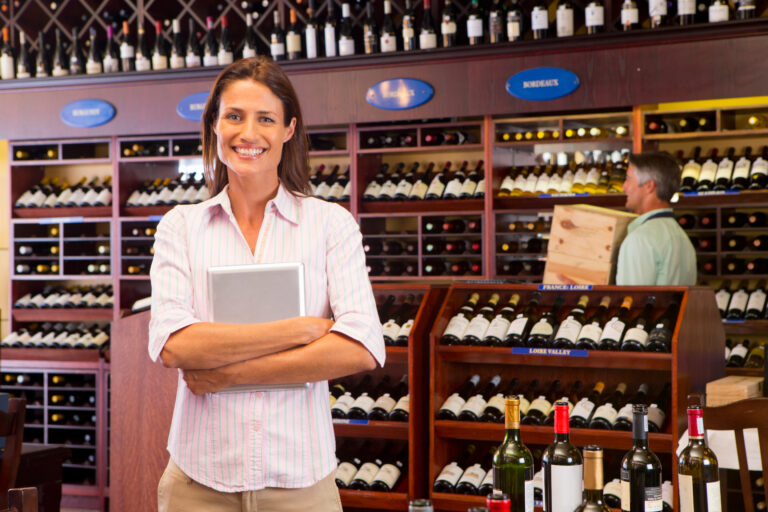 Image of liquor store owner holding digital tablet